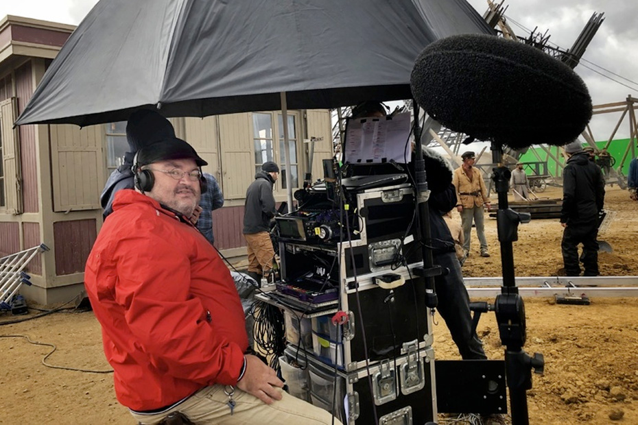 A production sound mixer at his cart on a muddy period film set